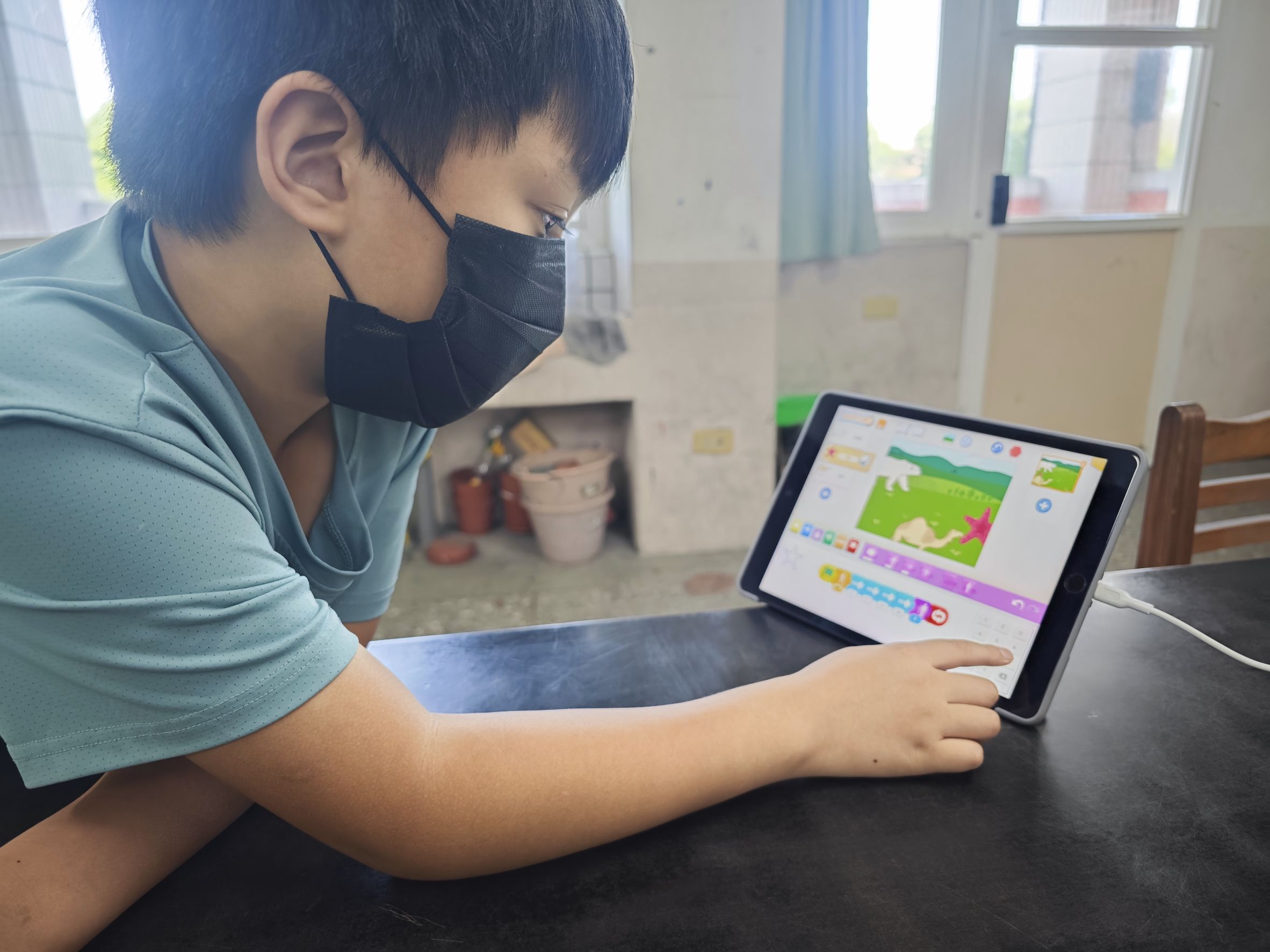 低年級學員操作 ScratchJr 拖曳指令積木,親手打造包含跳躍、碰撞等動作機制的經典遊戲闖關畫面與生態故事
